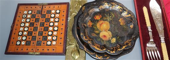 A novelty travelling chess set, two papier mache plates, two finger plates and servers